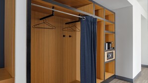Un armario moderno con estantes de madera, una barra para colgar ropa y una cortina.