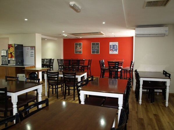 A restaurant with wooden tables and chairs, a coffee machine, and a menu board on the wall. - 247 Hotel (Oldham)