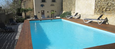 Piscine extérieure en saison, parasols, chaises longues