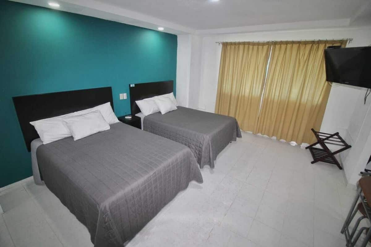 Habitación doble Deluxe, 2 camas matrimoniales | Tabla de planchar con plancha, wifi gratis y ropa de cama