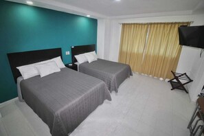 Habitación doble Deluxe, 2 camas matrimoniales | Tabla de planchar con plancha, wifi gratis y ropa de cama 