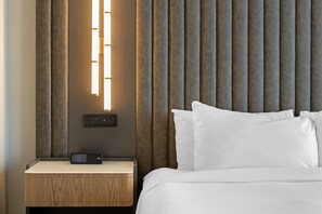 A modern hotel room with a wooden nightstand, a digital control panel, and a bed with white bedding. - Hotel Flor Tampa Downtown, Tapestry Collection by Hilton (Tampa)