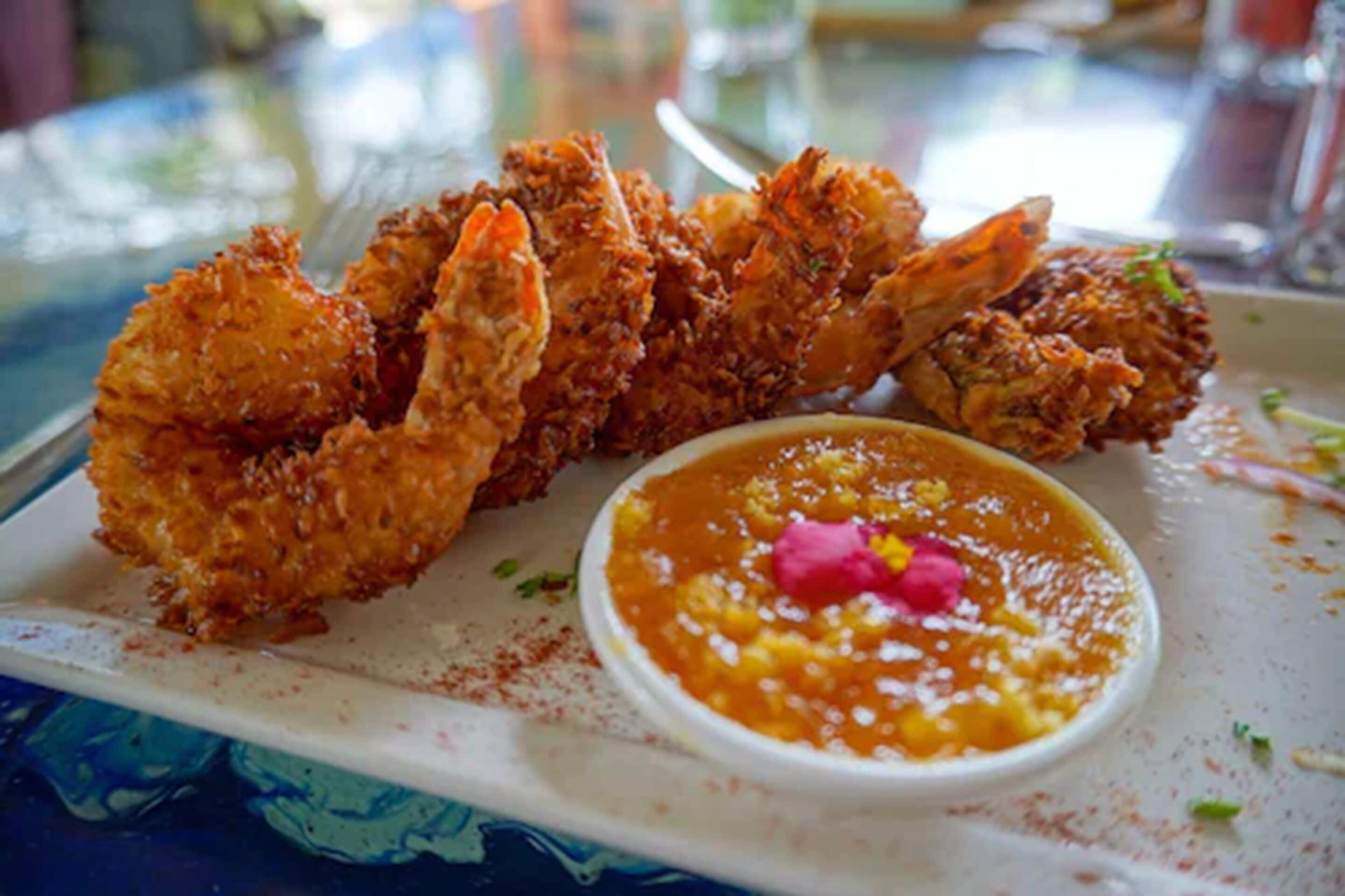 Un plato de camarones fritos con salsa para mojar.