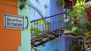 A reception sign on a building with a blue textured wall and a staircase. - Conchal Hotel (Cabo Velas)