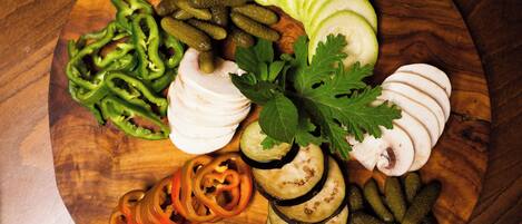 A wooden board with sliced vegetables and herbs.