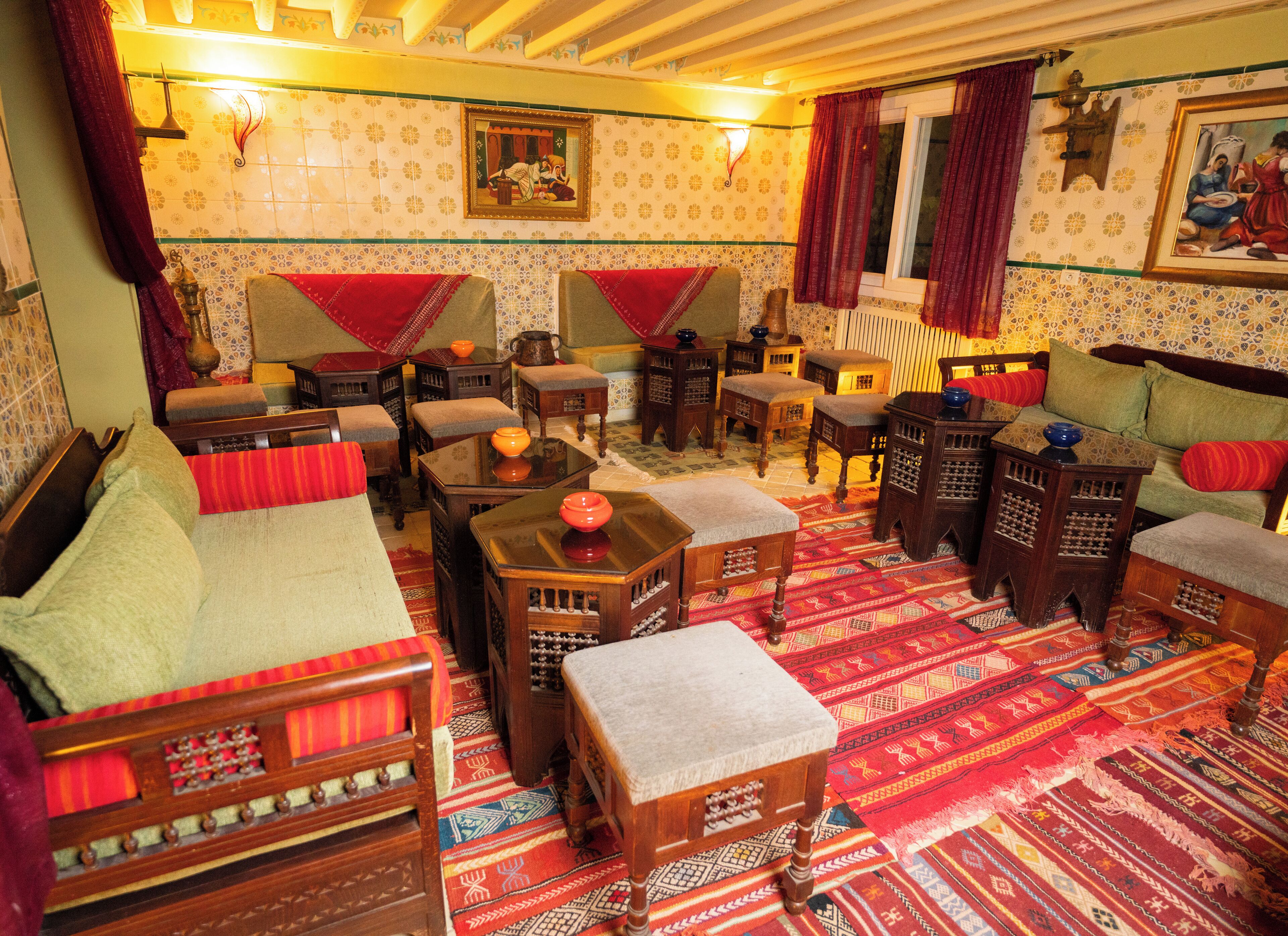 A traditional room with a sofa, tables, and a patterned carpet.