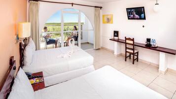 Hotelkamer met een bed, een bureau, een stoel, een televisie en een balkon met uitzicht.