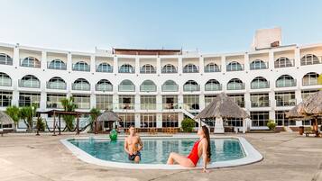 Una piscina al aire libre, sillones reclinables de piscina