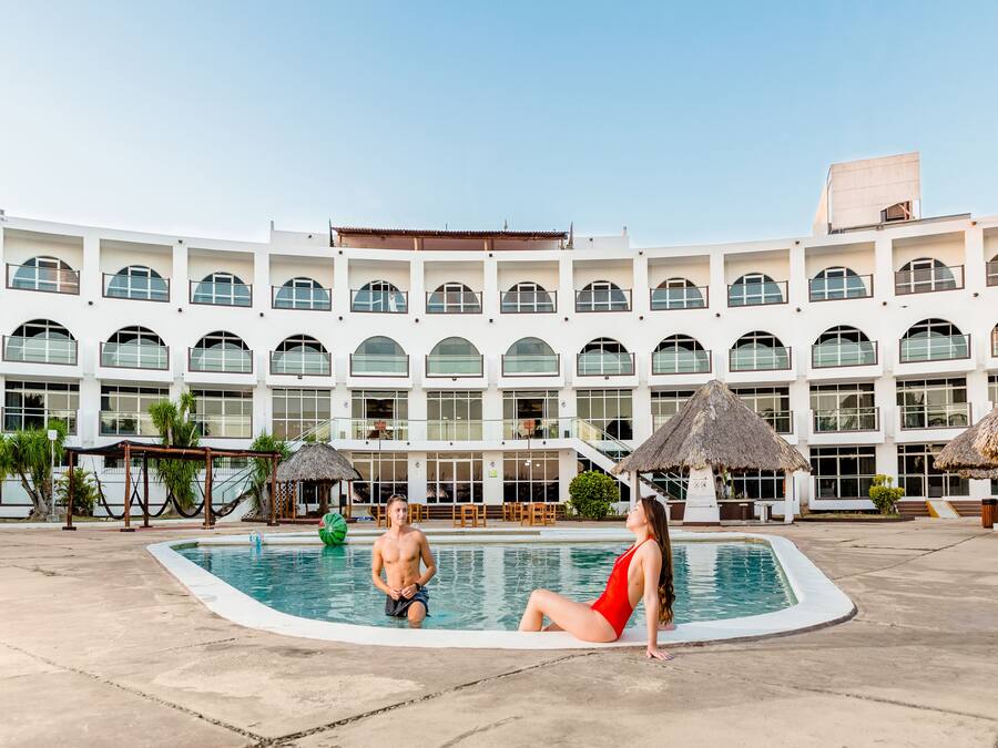 Una piscina al aire libre, sillones reclinables de piscina