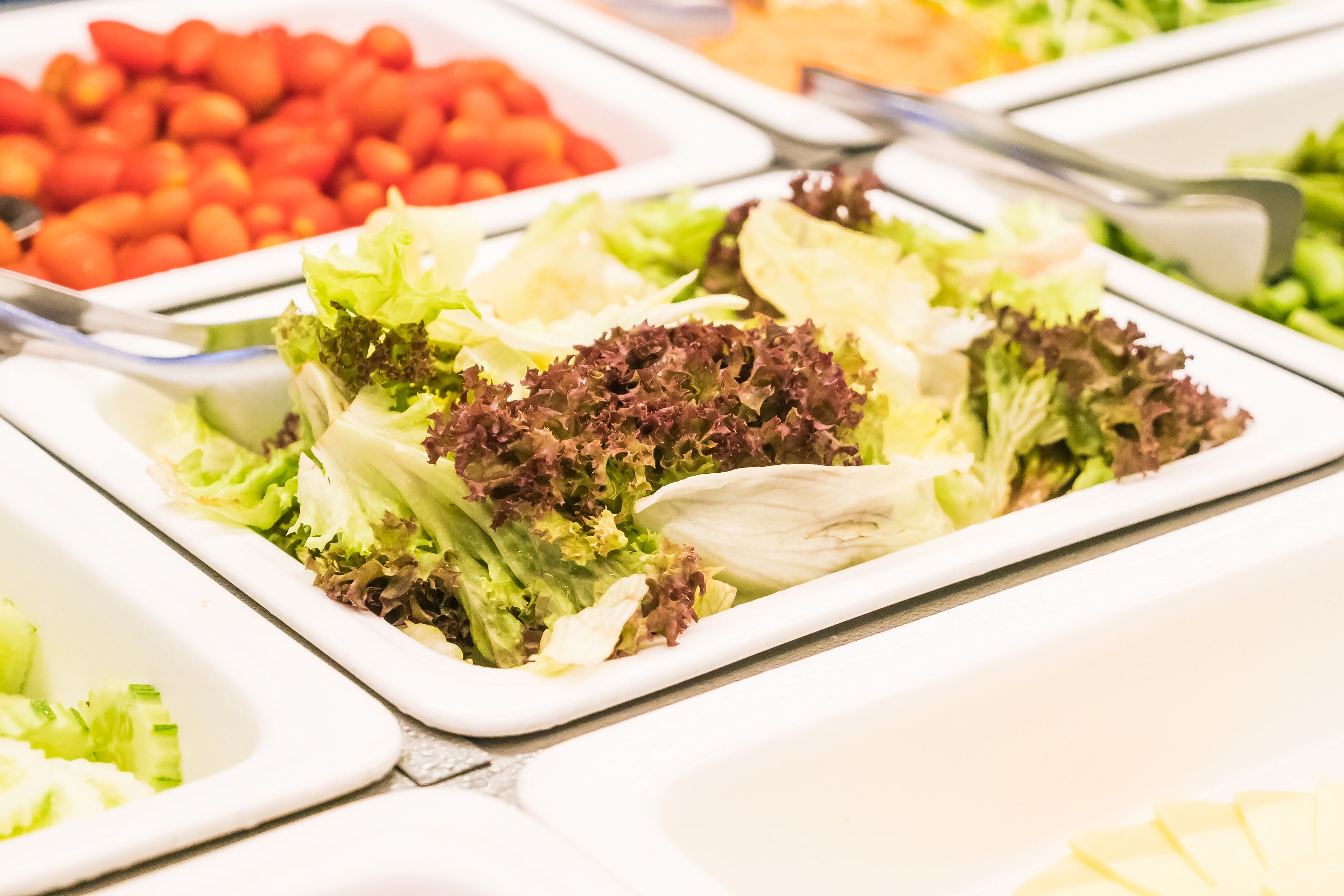 A buffet with various salads and vegetables.