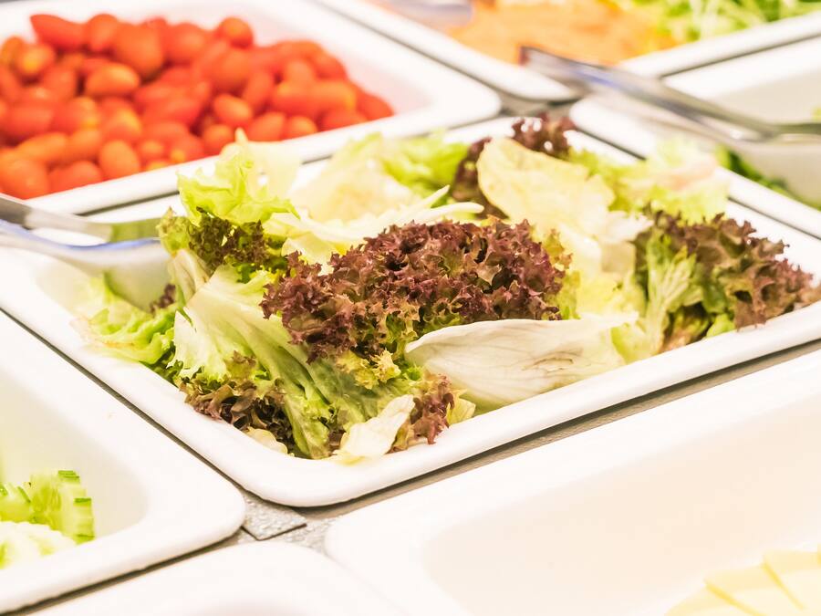 Un bufé con ensaladas y verduras variadas.