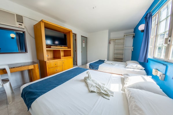 A hotel room with two beds, a desk, a television, and a wardrobe.