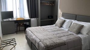 A bedroom with a bed, a desk, a chair, and a wardrobe. - Hotel Inn (Taormina)