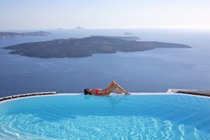 Una piscina al aire libre, tumbonas