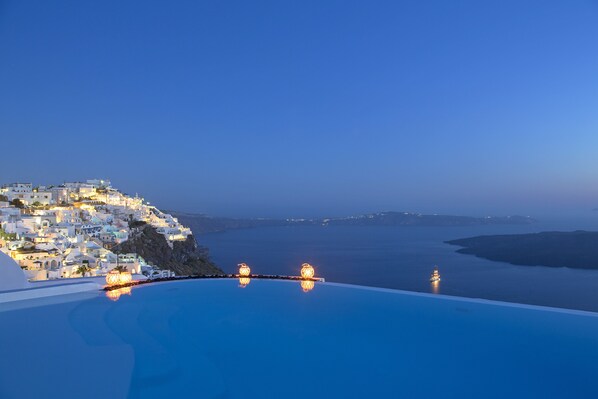 Un pueblo costero con una amplia piscina infinita con vistas al mar.