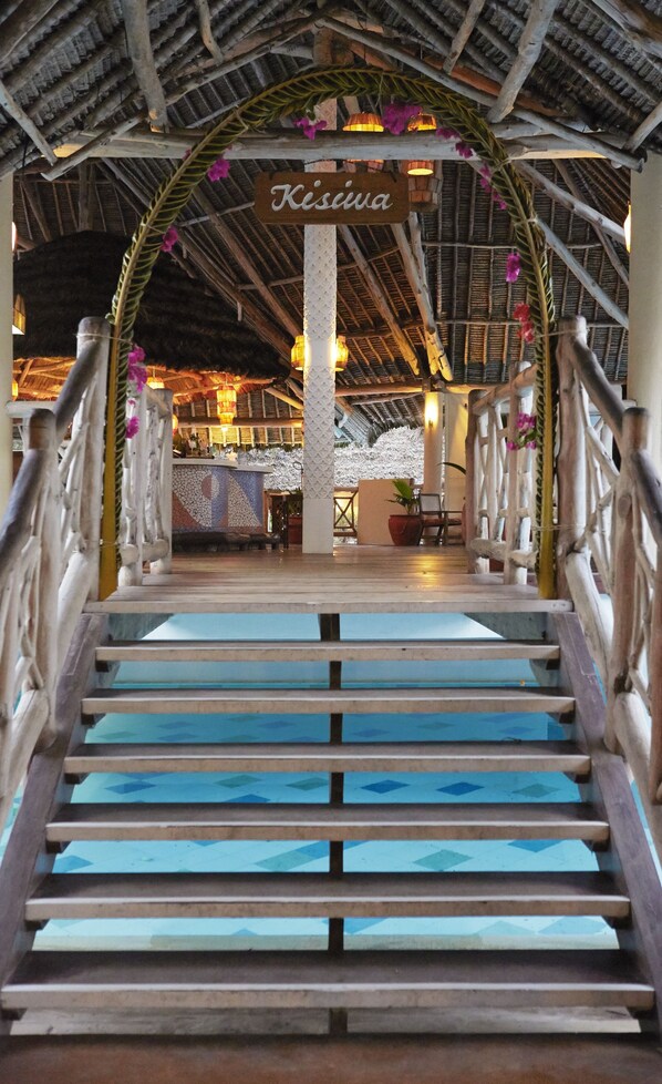 A staircase leading to a covered area with a sign reading "Kisiva". - Neptune Palm Beach Boutique Resort & Spa All Inclusive (Diani Beach)