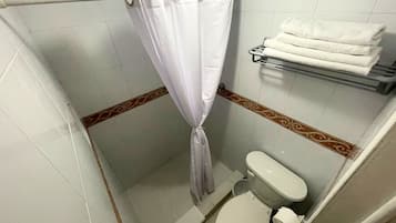 A small bathroom with a shower curtain, a toilet, and a towel rack.
