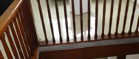 Una escalera de madera con barandilla que baja a un nivel inferior. Un letrero indica que hay un hotel llamado "Casa Sabellum" abajo.