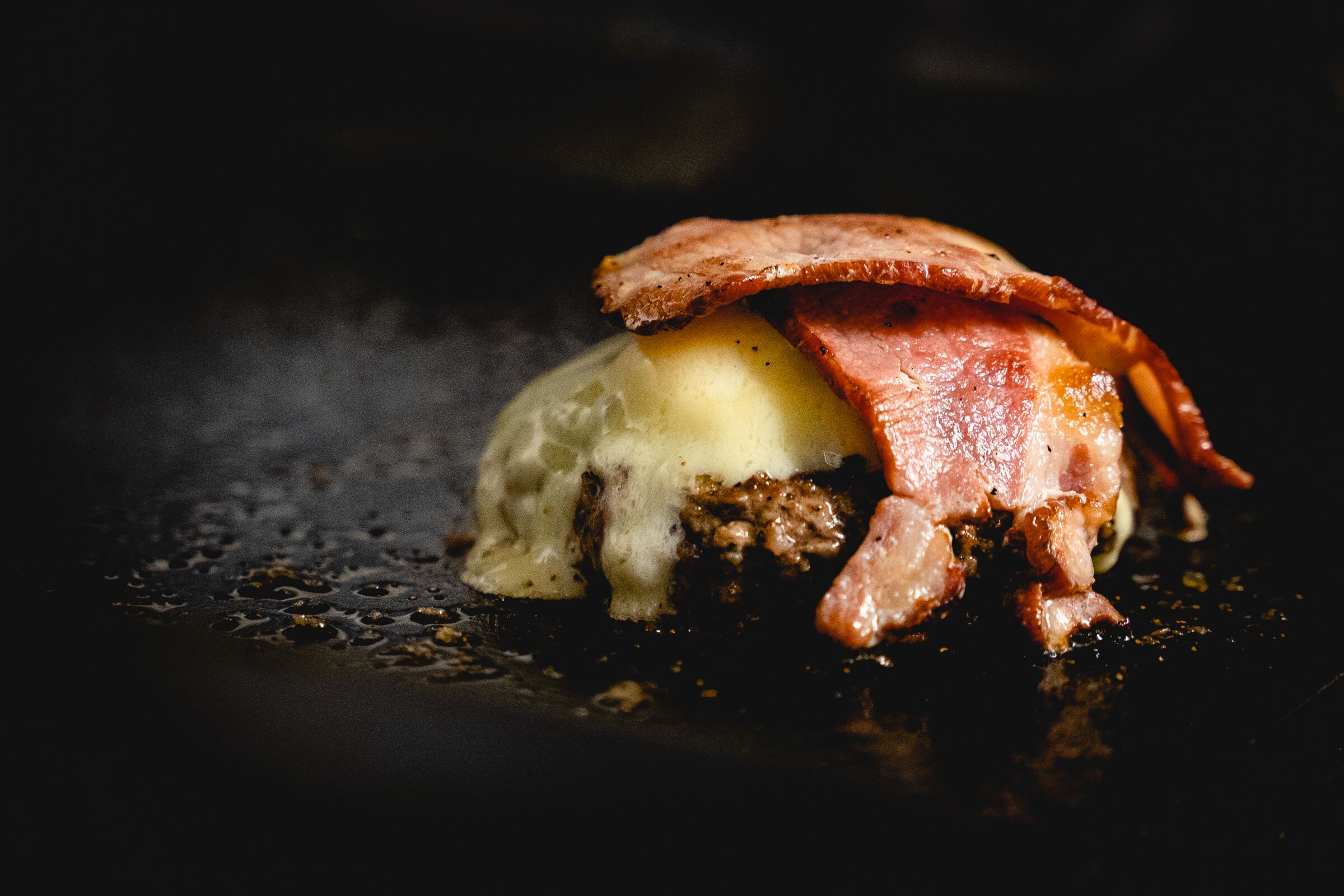 A dish with a creamy base, topped with crispy bacon.