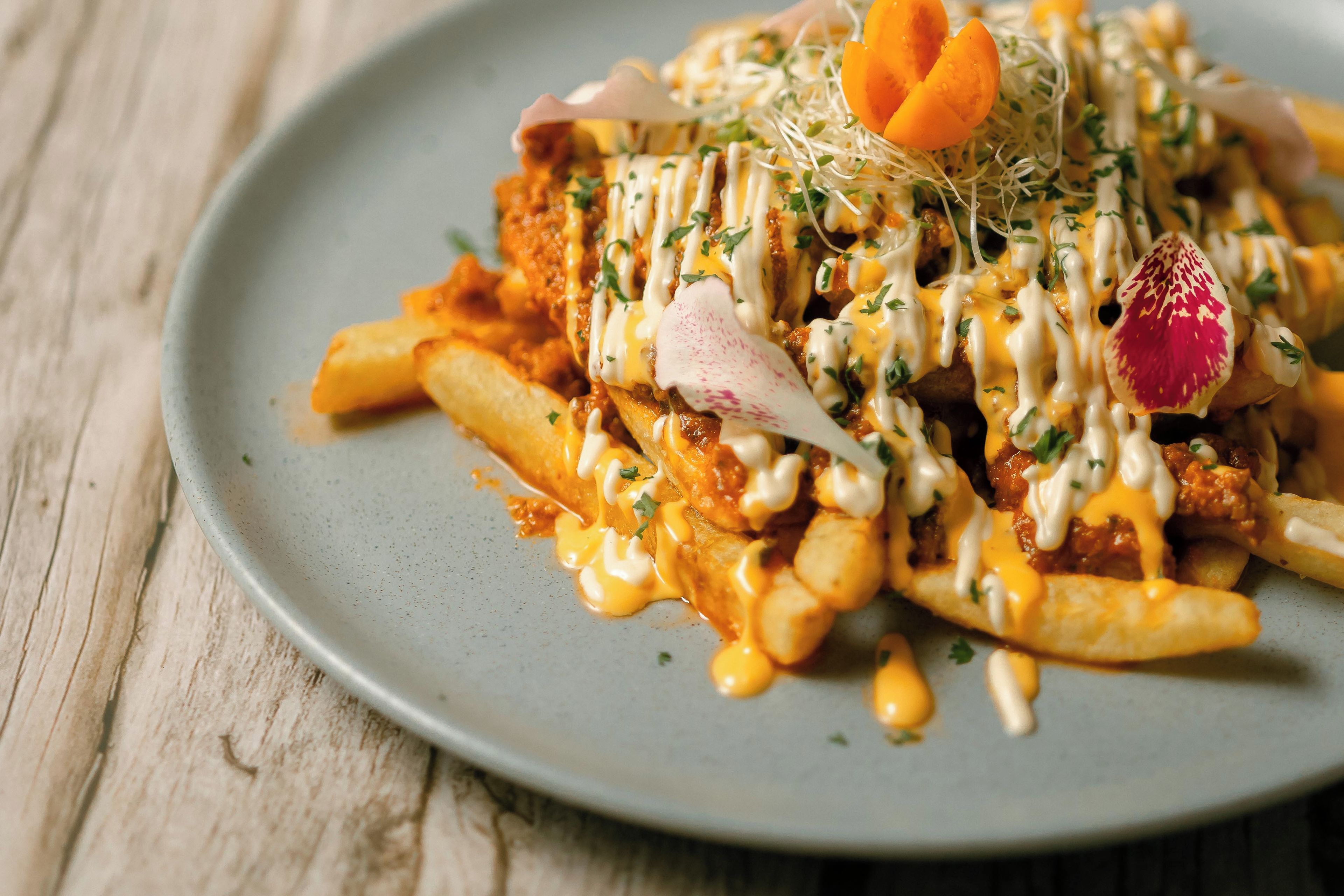 A plate of food with fries, a meat patty, and a sauce.