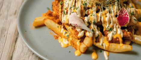 A plate of food with fries, a meat patty, and a sauce.