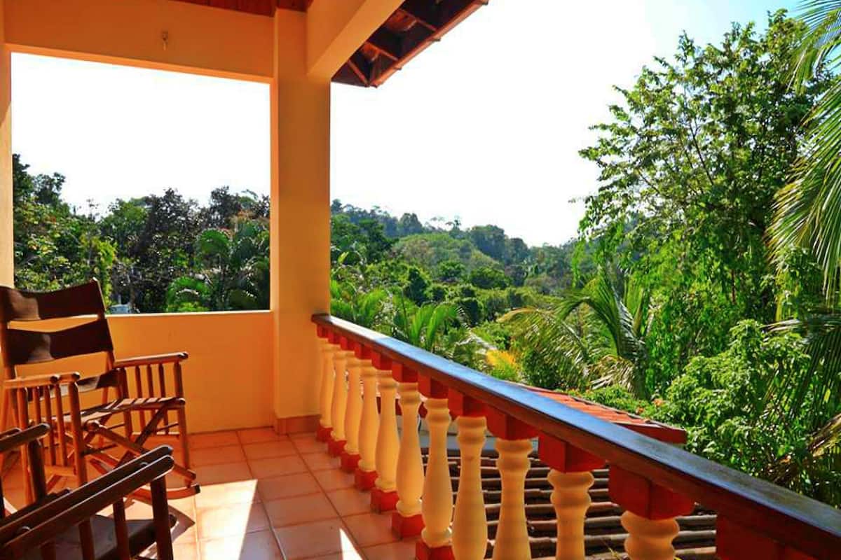 A balcony with a view of a lush green landscape.