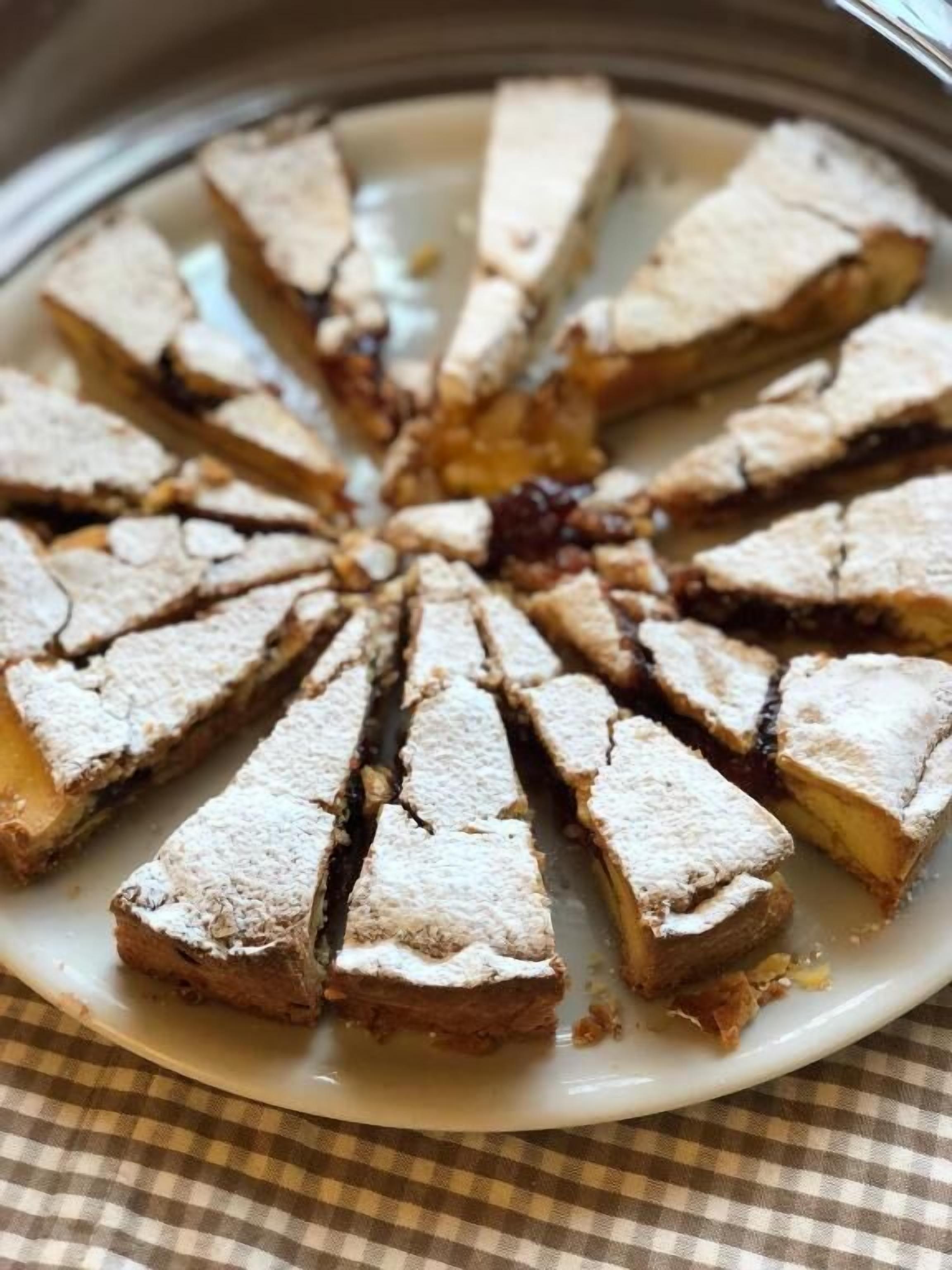 A round dessert with triangular slices on a white plate.