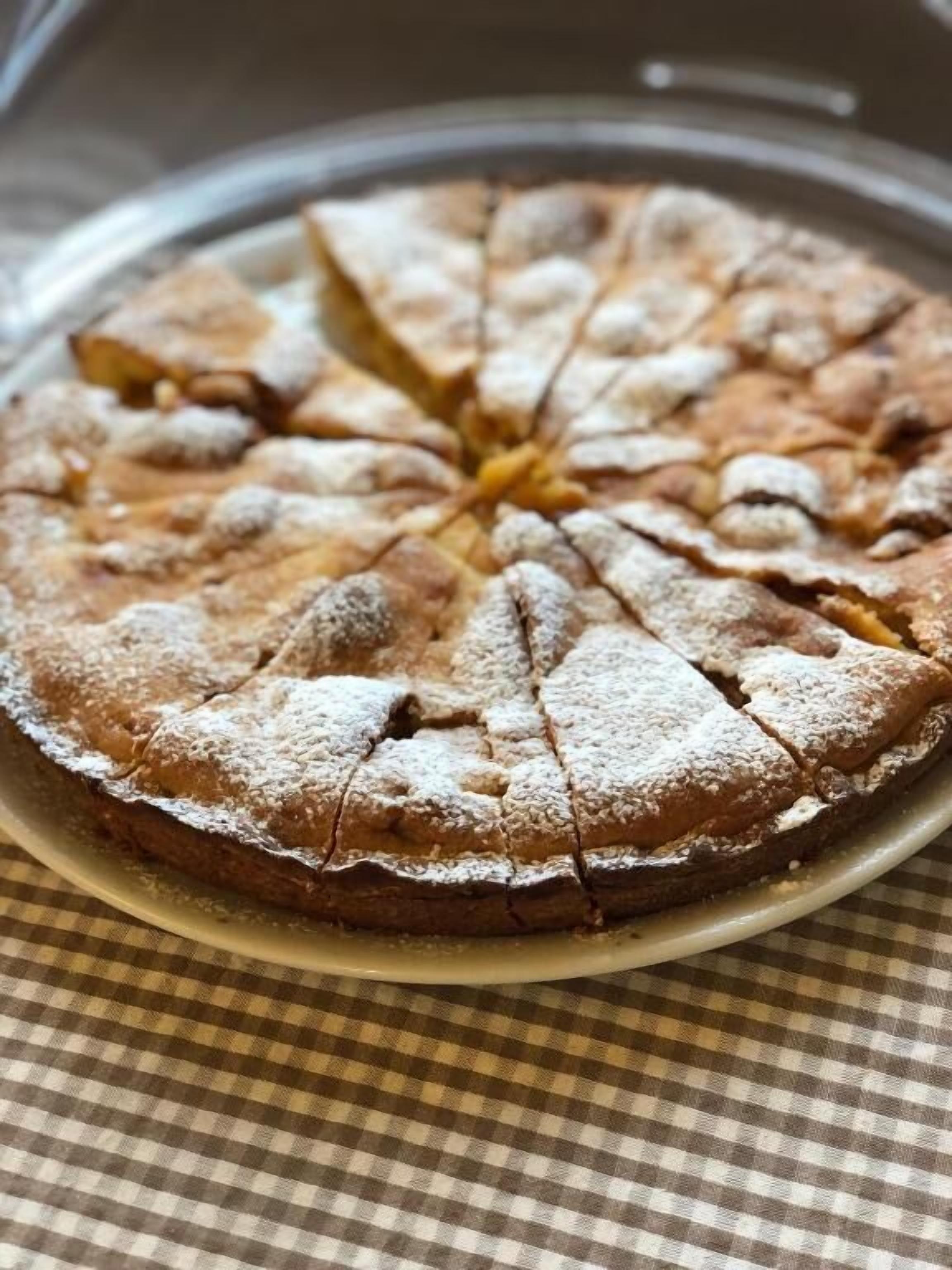 Un gâteau rond, saupoudré de sucre glace sur le dessus, posé sur une assiette.