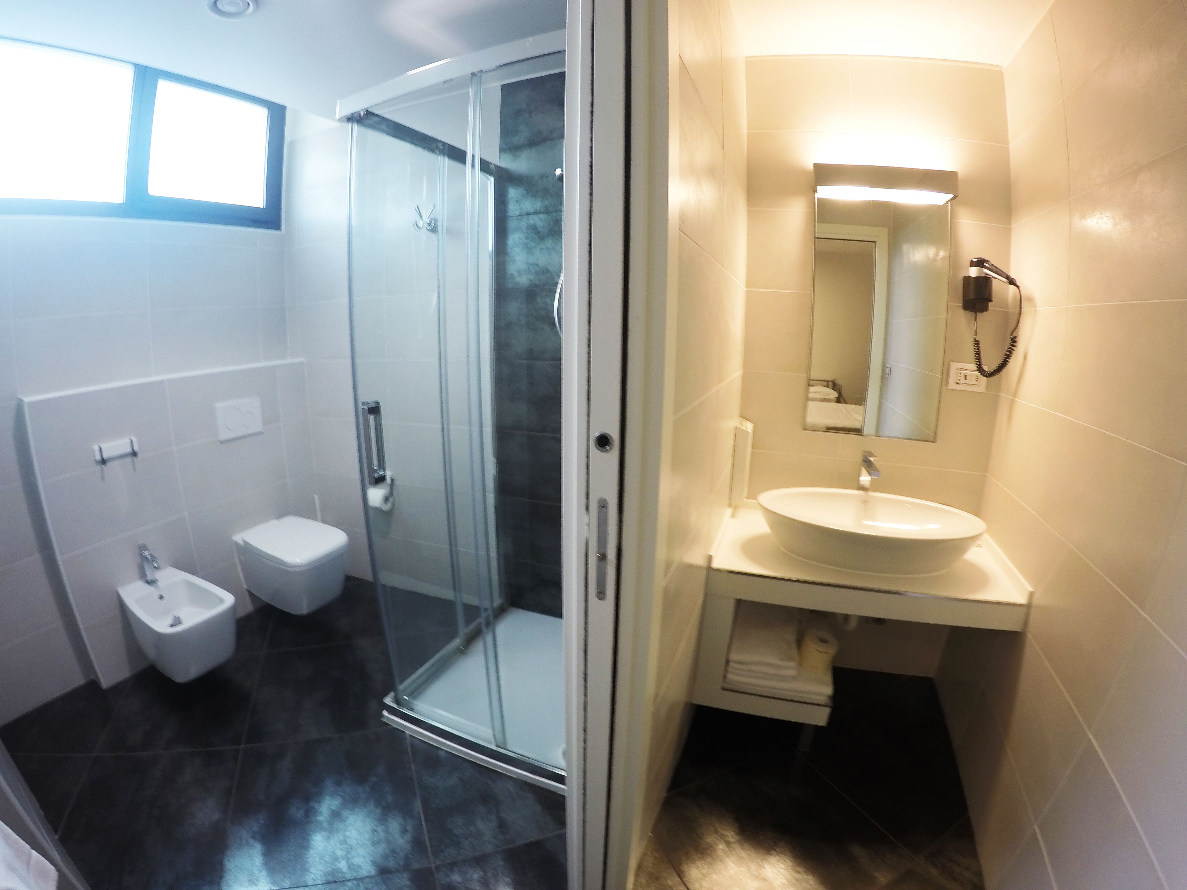 Une salle de bain moderne avec une douche à parois de verre, des toilettes et un lavabo avec un miroir.