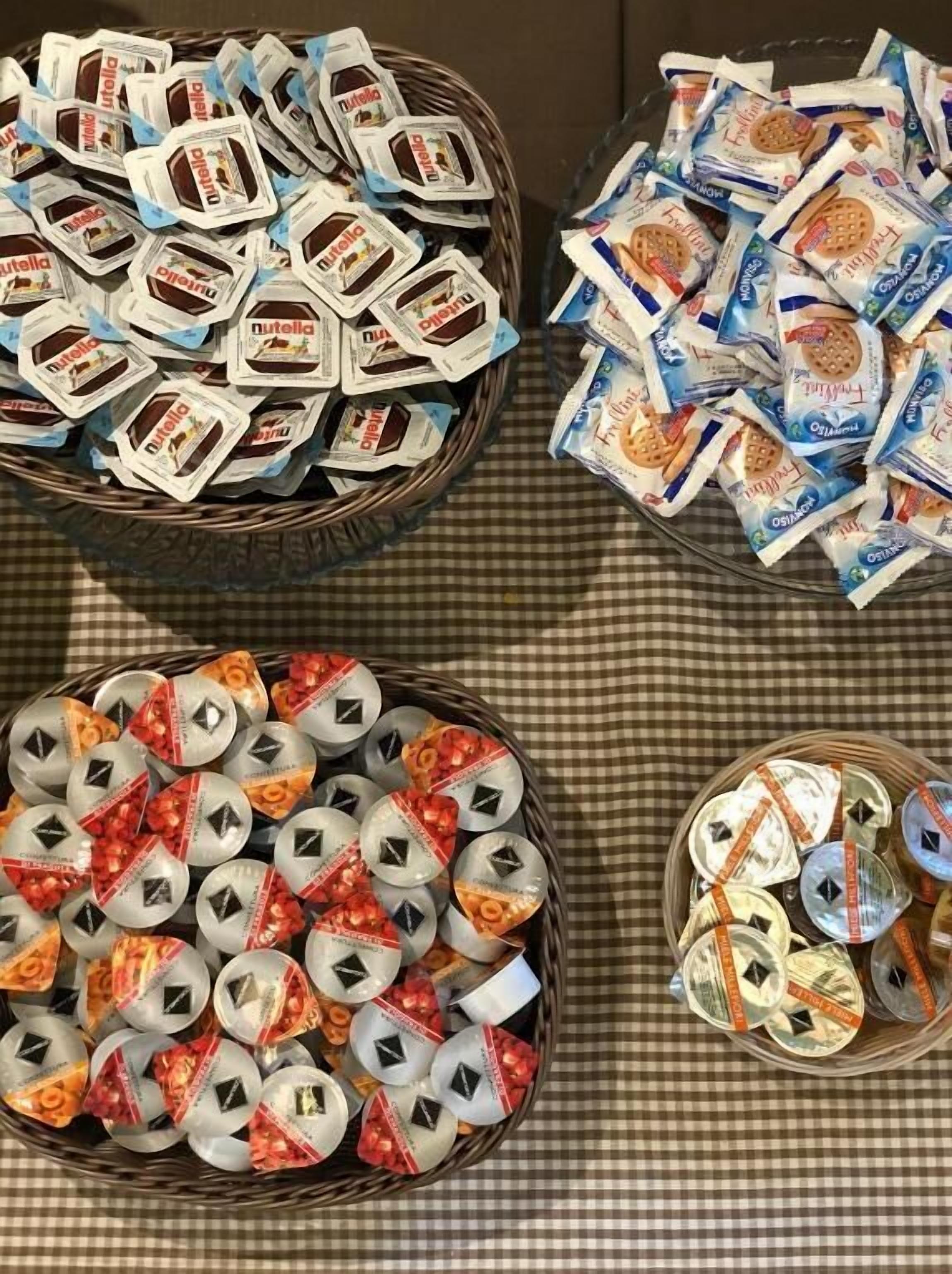 Three baskets filled with packaged food items, likely for a gathering or event.