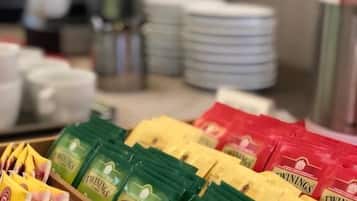 A wooden display case with Twinings tea packets in green, yellow, and red packaging.