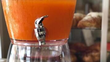 Un distributeur de jus avec une étiquette indiquant « SUCCO ACE », posé sur un plateau avec une serviette rouge.