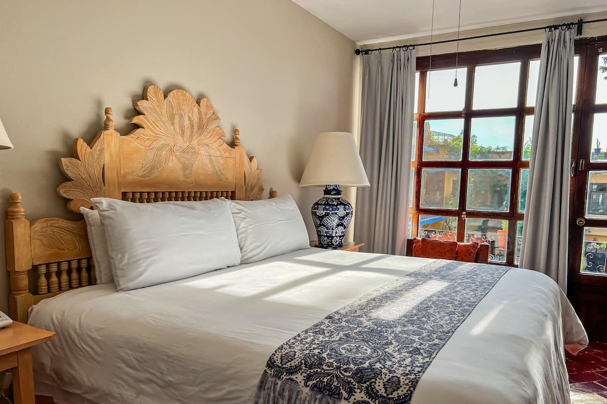 Cama bem arrumada com colcha estampada e cabeceira decorativa.