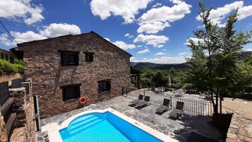 Een seizoensgebonden buitenzwembad, parasols voor strand/zwembad