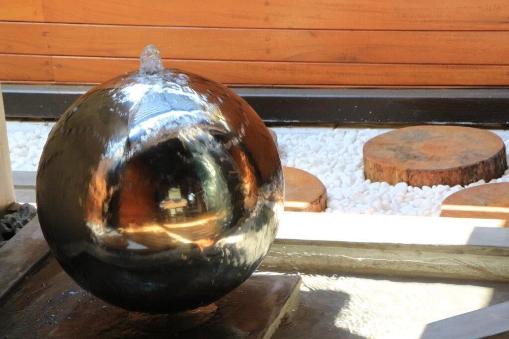 Un objeto esférico metálico sobre una superficie de madera.