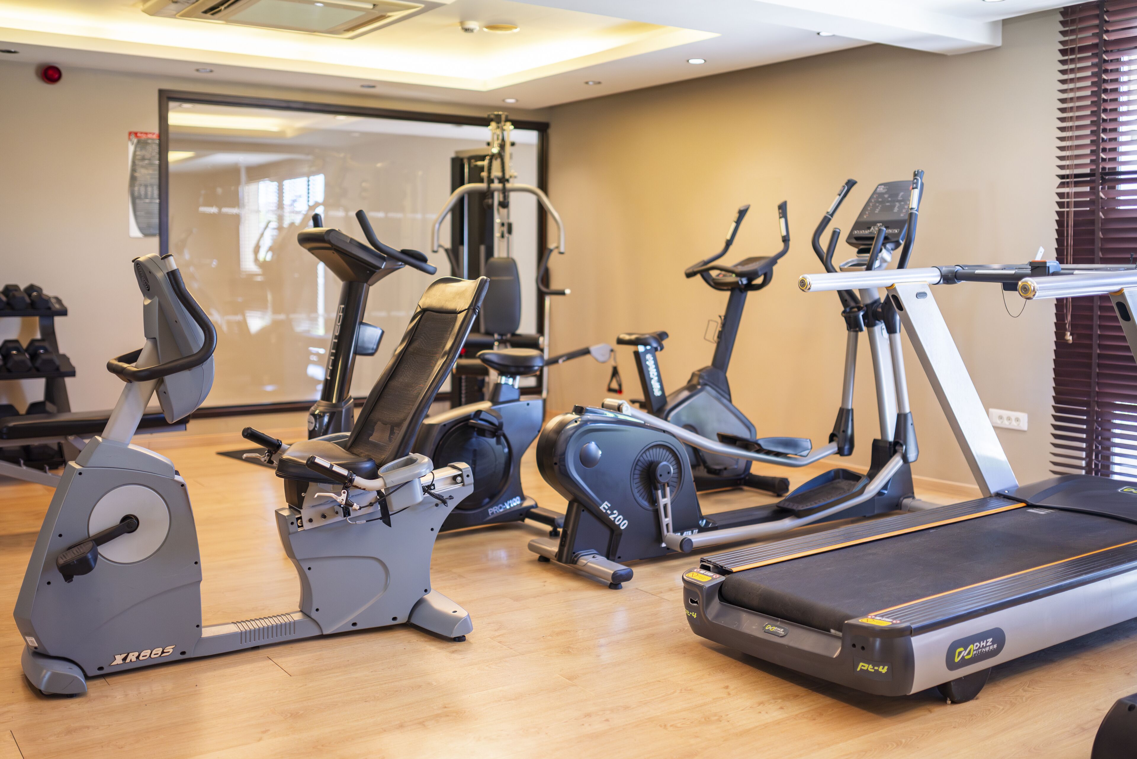 A gym with various exercise machines including treadmills and stationary bikes.