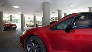 A parking garage with multiple cars, including a red car in the foreground. - Central Hotel Eschborn (Eschborn)