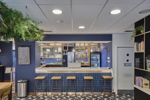 Uma área de bar com banquetas, balcão e cardápio.