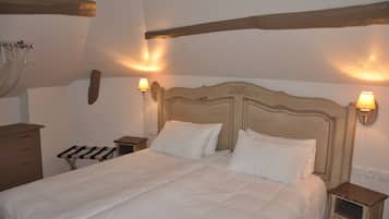 Een slaapkamer met een groot bed, twee nachtkastjes, een houten dressoir en wandlampen.