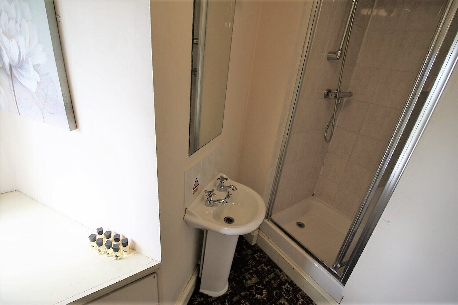 Un baño con lavabo, espejo y ducha.