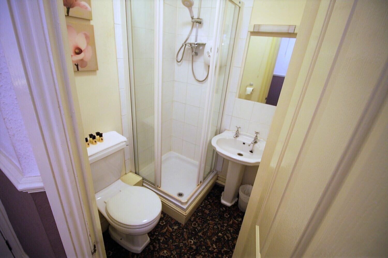 A small bathroom with a toilet, a shower, and a sink.