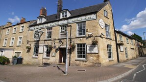 A traditional stone building with multiple signs for 'The Kings Arms' and 'Arkel's Ales'. - The Kings Arms Chipping Norton (Chipping Norton)