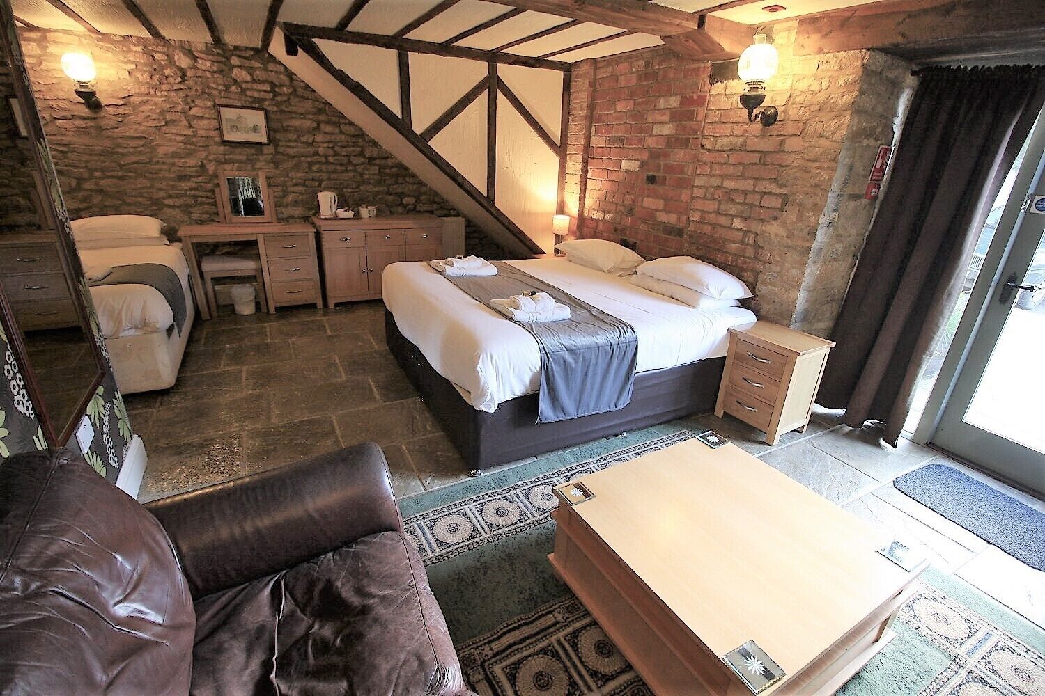 Une pièce confortable avec un lit, un bureau et une chaise. Un escalier mène à un niveau supérieur.