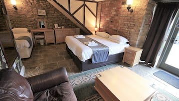 Une pièce confortable avec un lit, un bureau et une chaise. Un escalier mène à un niveau supérieur.