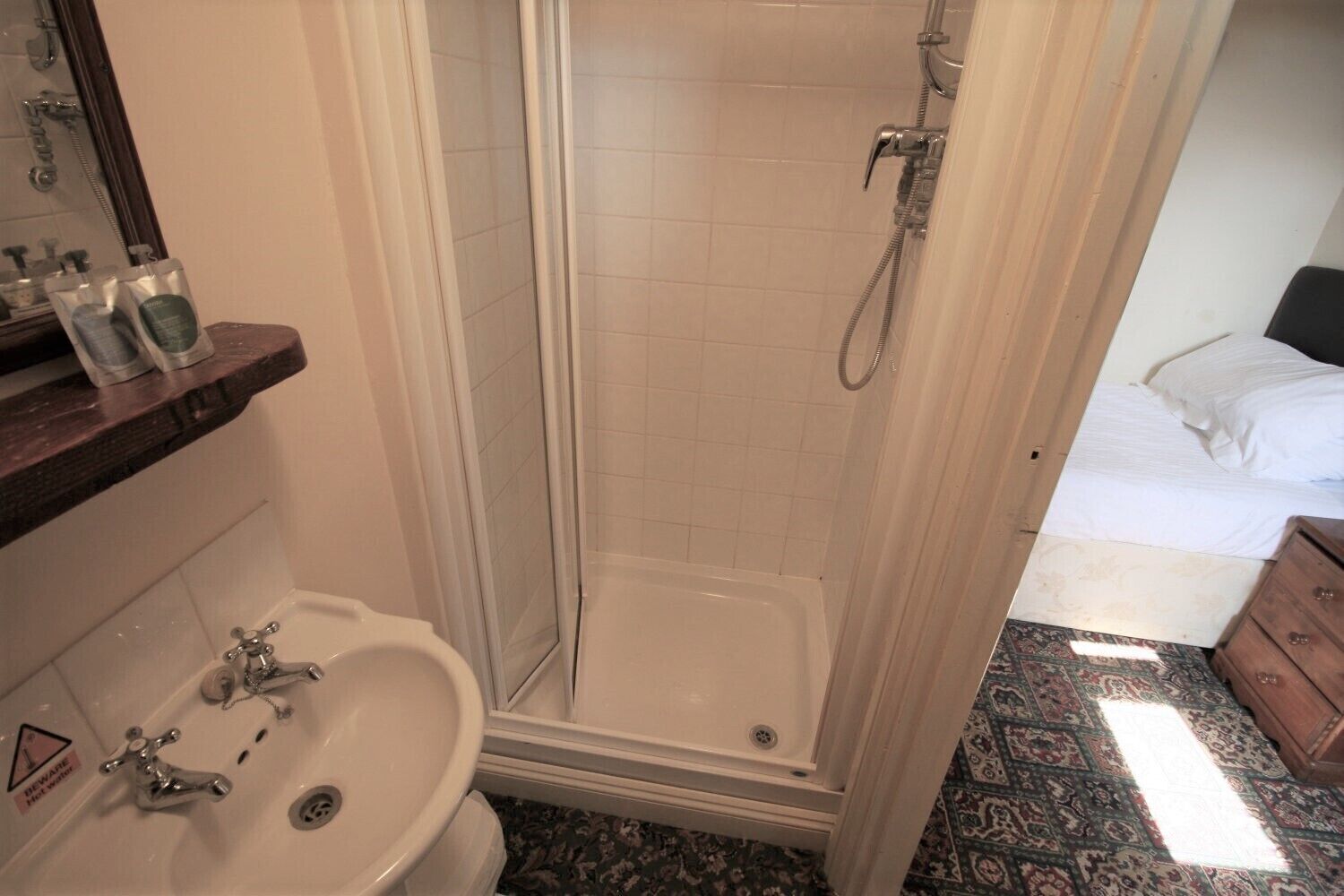 A bathroom with a shower, sink, and toilet.