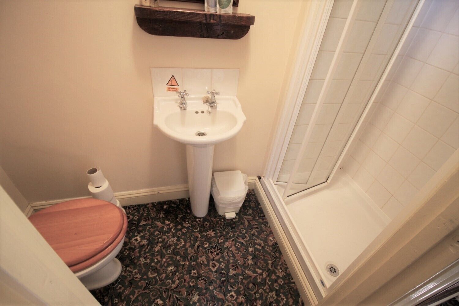 Un baño pequeño con inodoro, lavamanos y ducha.