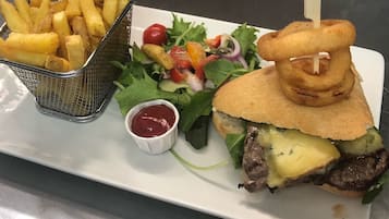 Une assiette avec un hamburger, des frites et une salade.