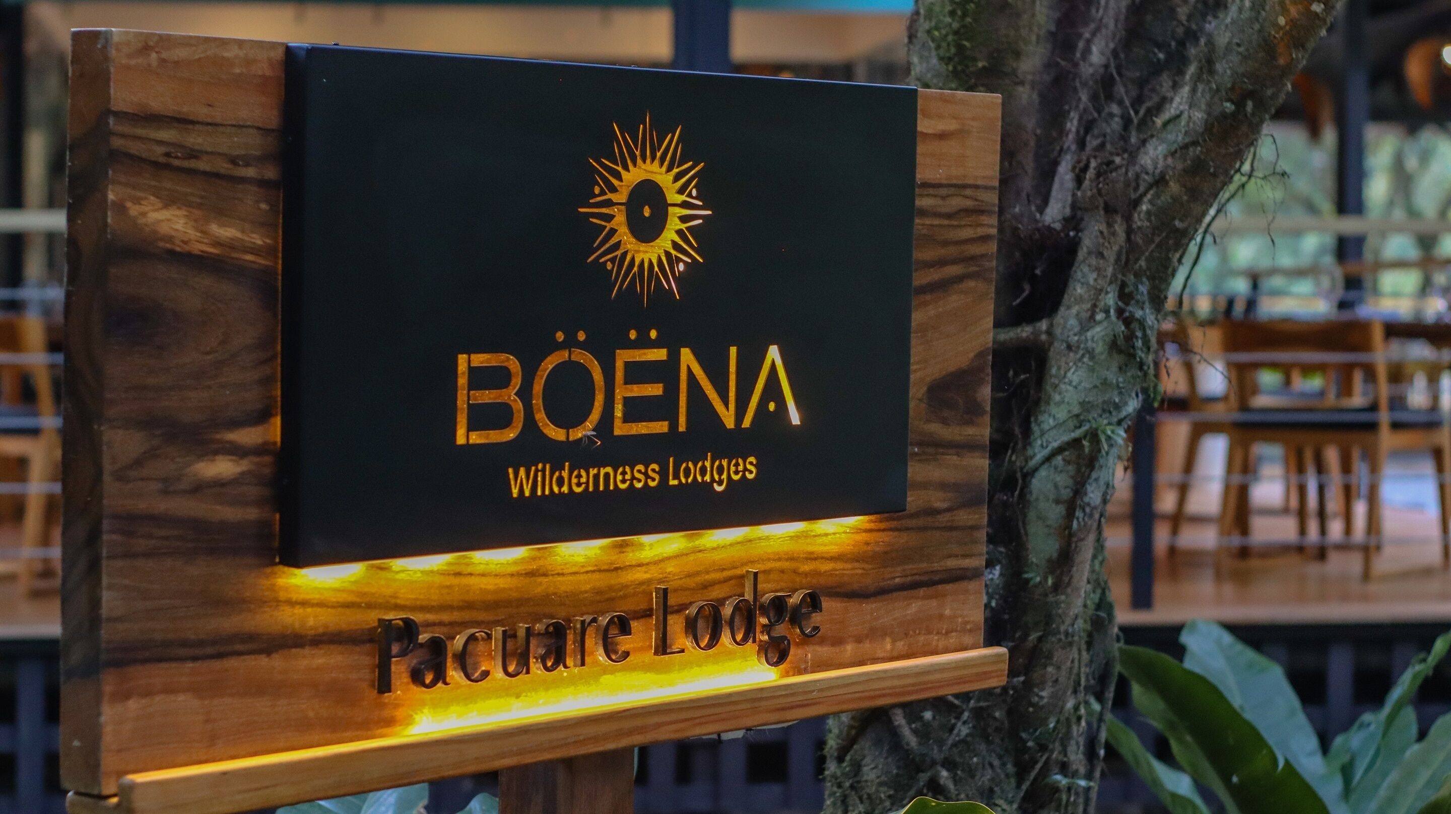 Señal para Bøena Wilderness Lodges con un emblema de sol, indicando un alojamiento enfocado en la naturaleza.