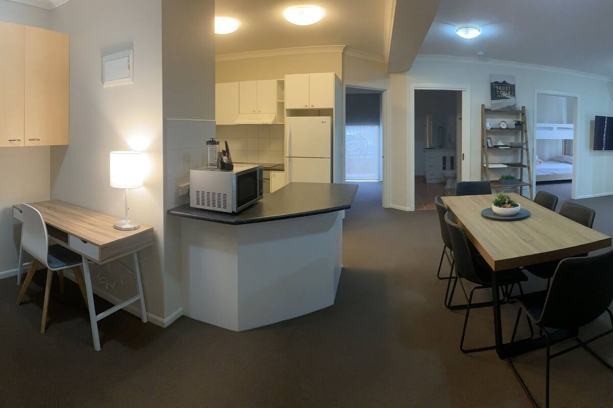 A modern apartment with a kitchen, dining area, and living room.