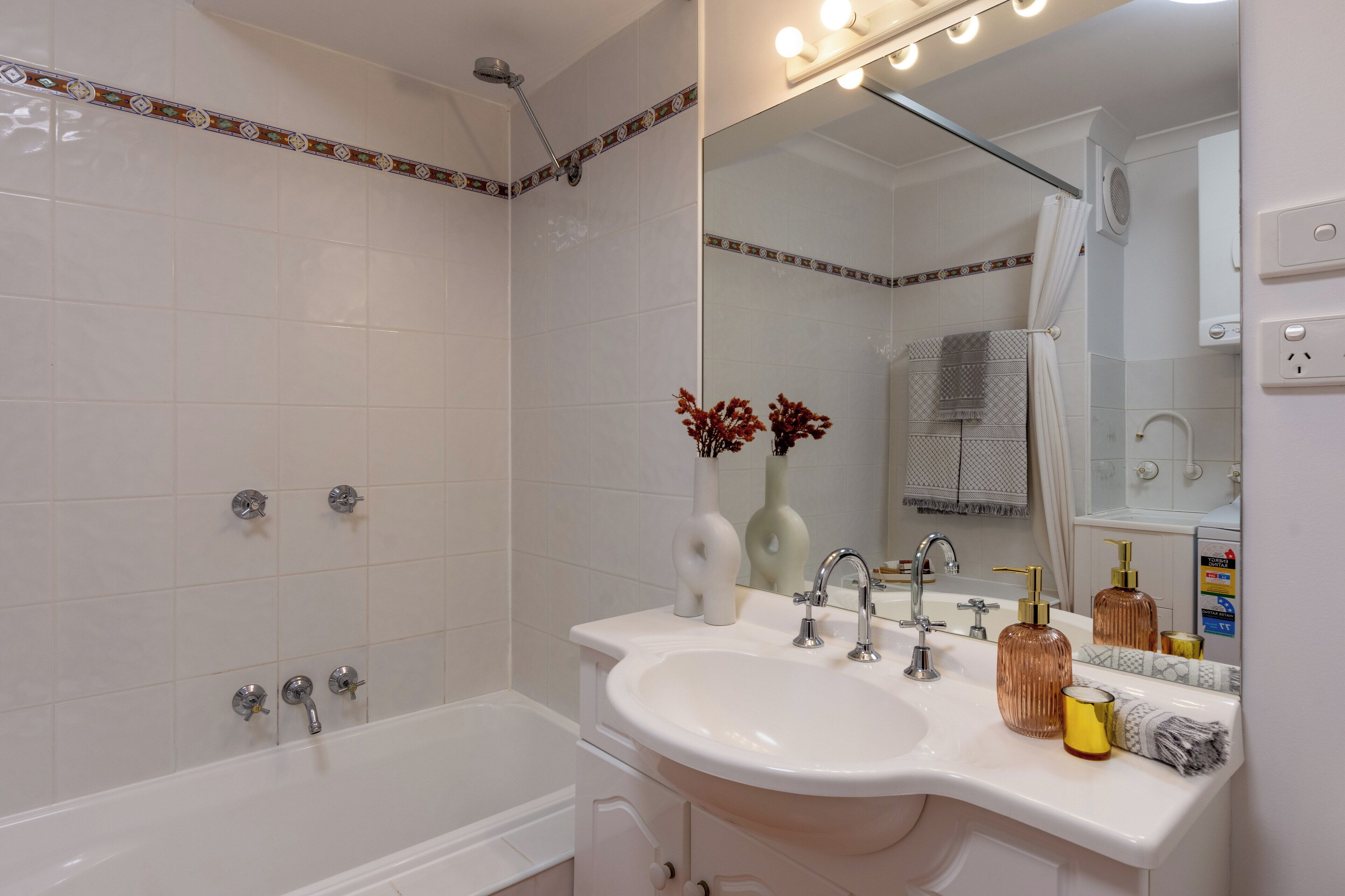 A bathroom with a bathtub, a sink, and a mirror.